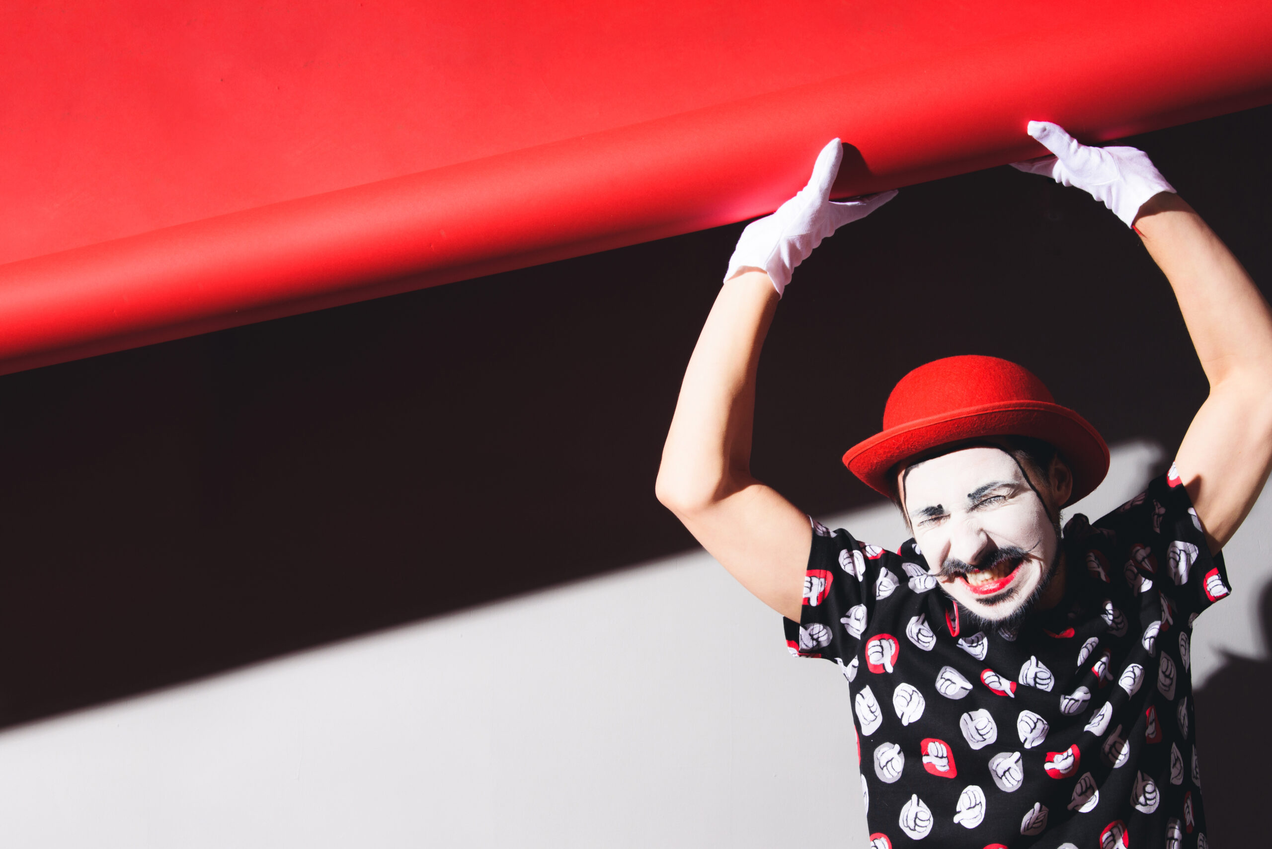 cheerful mime picks up the background and grimaces in the studio